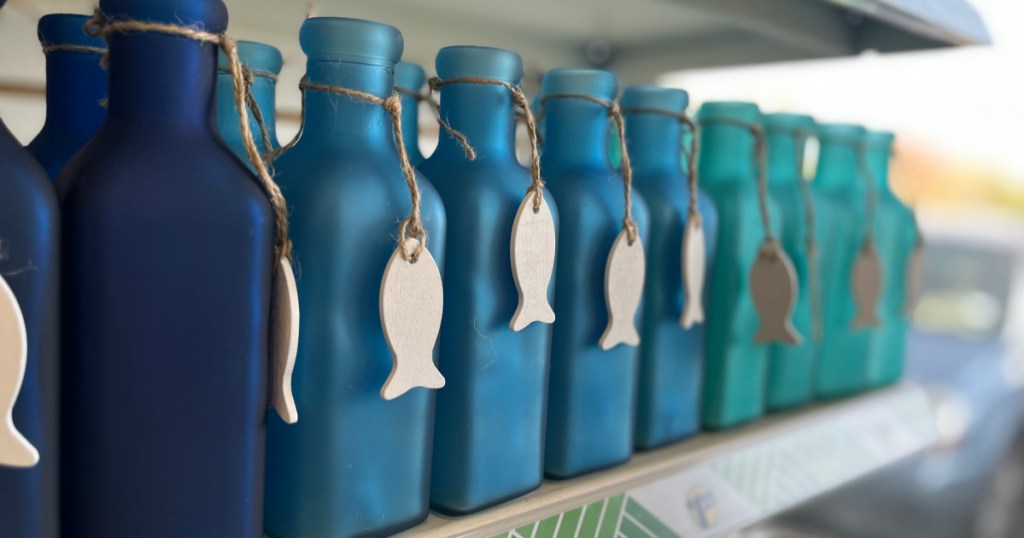 blue glass bottles with fish charms on store shelf