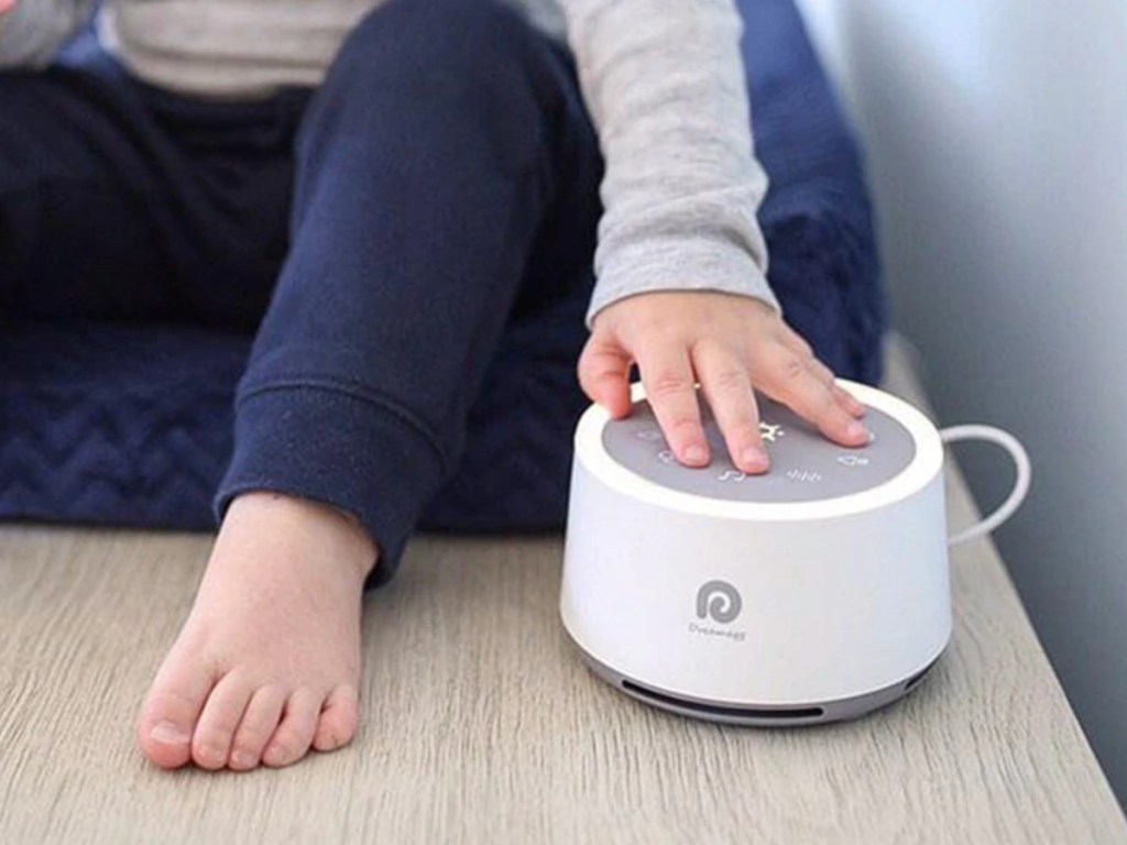 child with hand on top of Dreamegg White Noise Machine