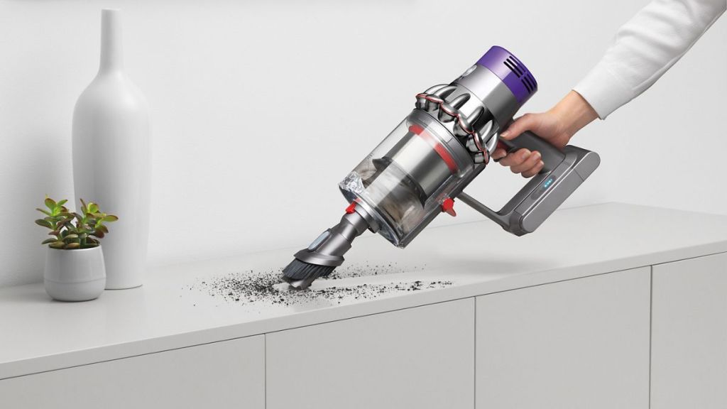 hand using a Dyson vacuum