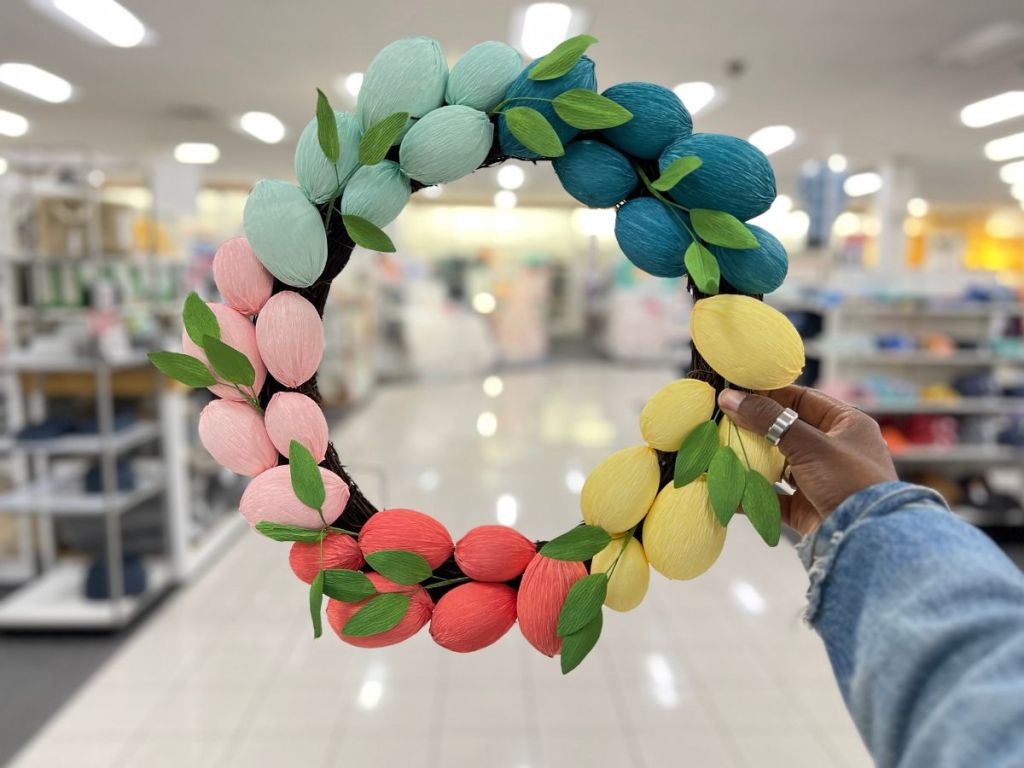 hand holding onto brightly colored egg Easter wreath