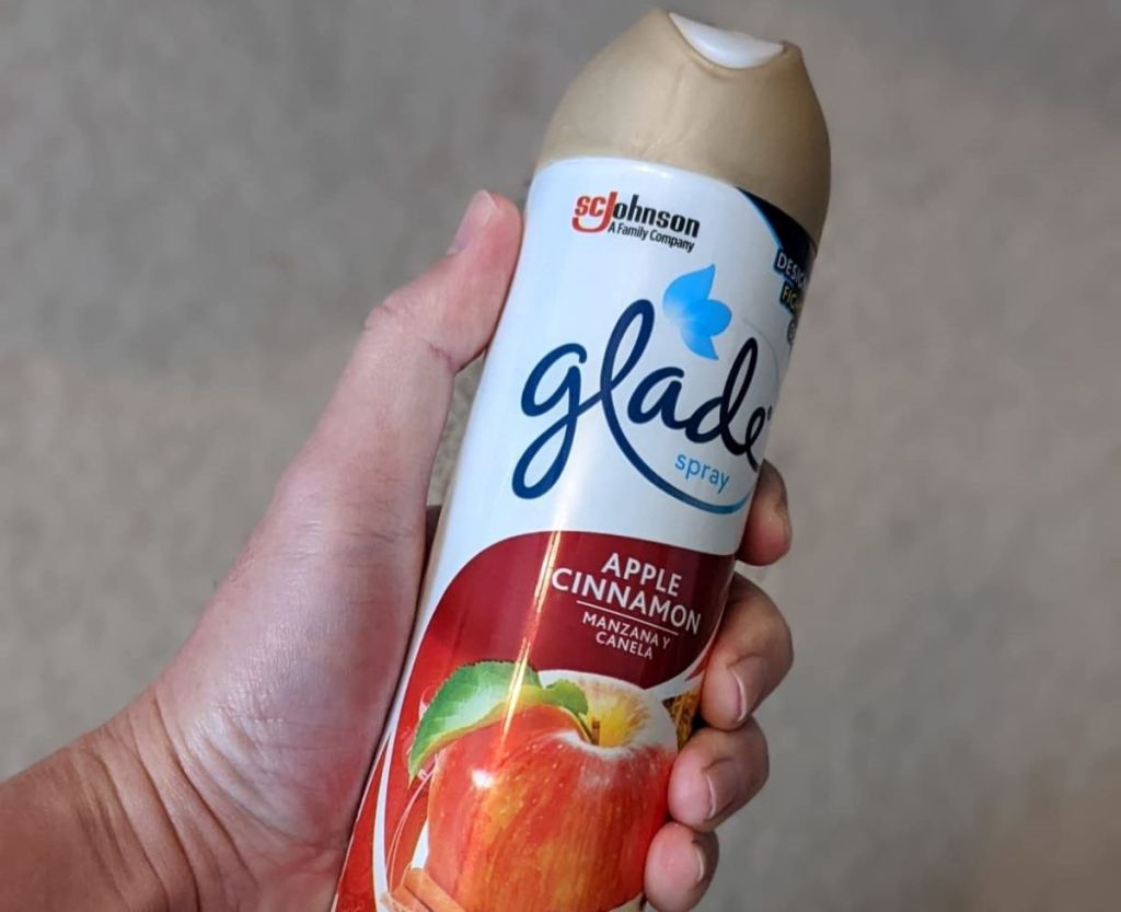 hand holding a Glade Apple Cinnamon air freshener