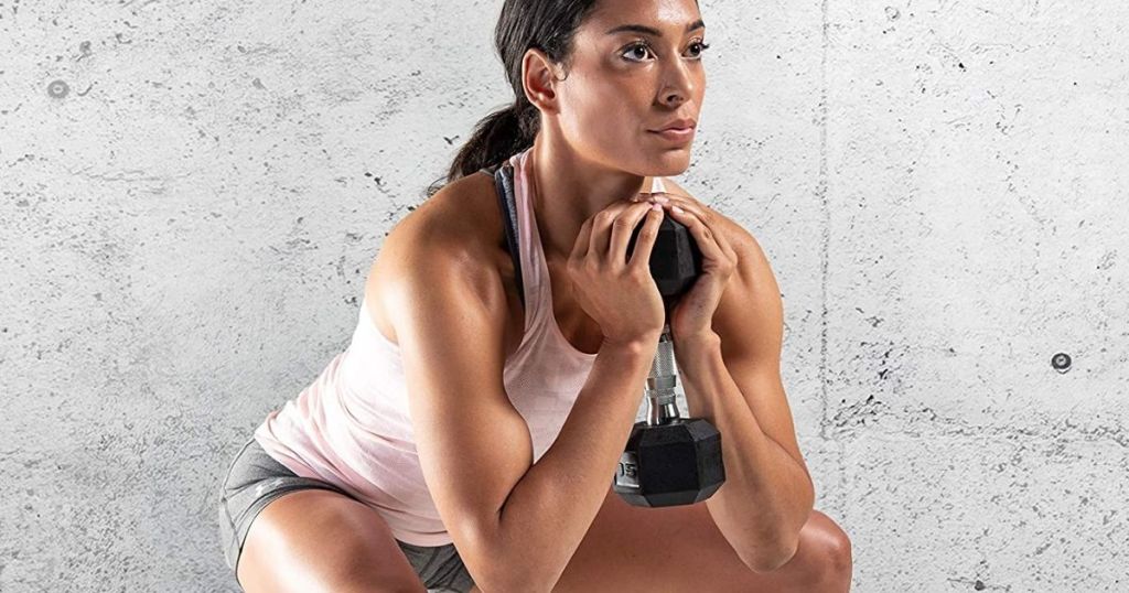 woman squatting with a dumbbell