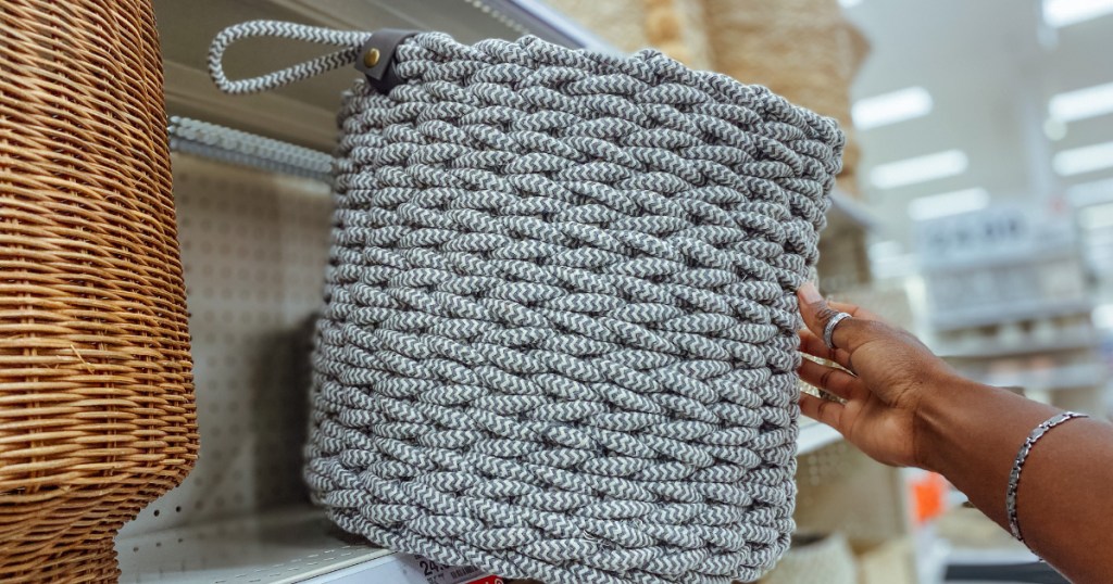 Hand pulling coiled rope basket off shelf