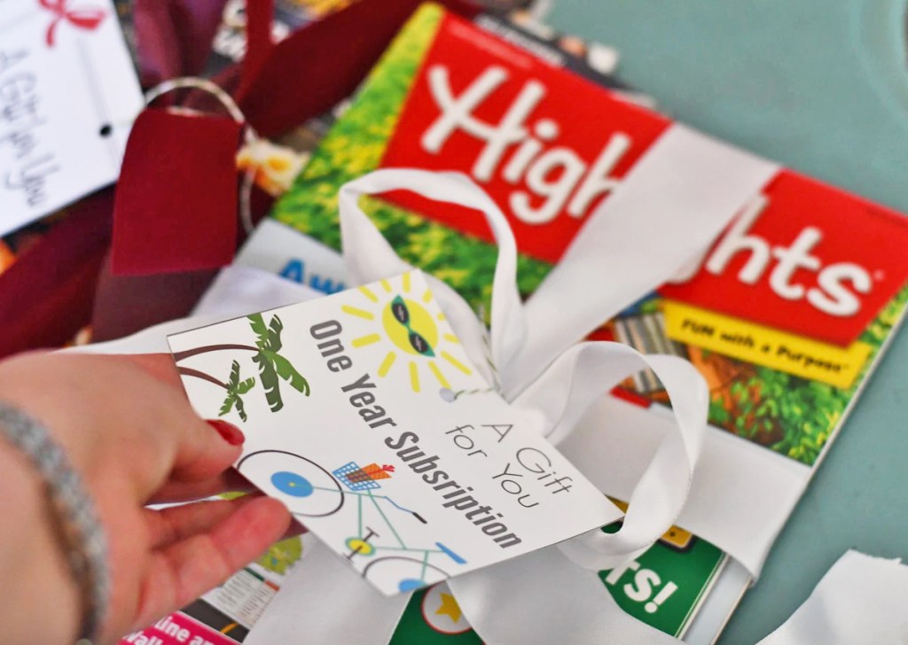 holding gift tag on highlights magazine