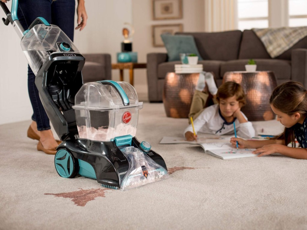 woman using carpet cleaner to clean carpet