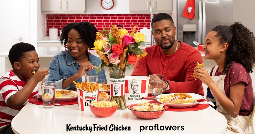 family eating KFC with bucket of chicken + flowers
