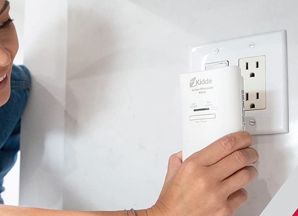 woman plugging Kidde Carbon Monoxide Detector into wall