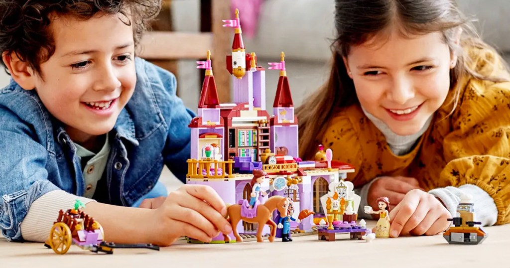 boy and girl playing with LEGO Disney Belle and the Beast’s Castle set on floor