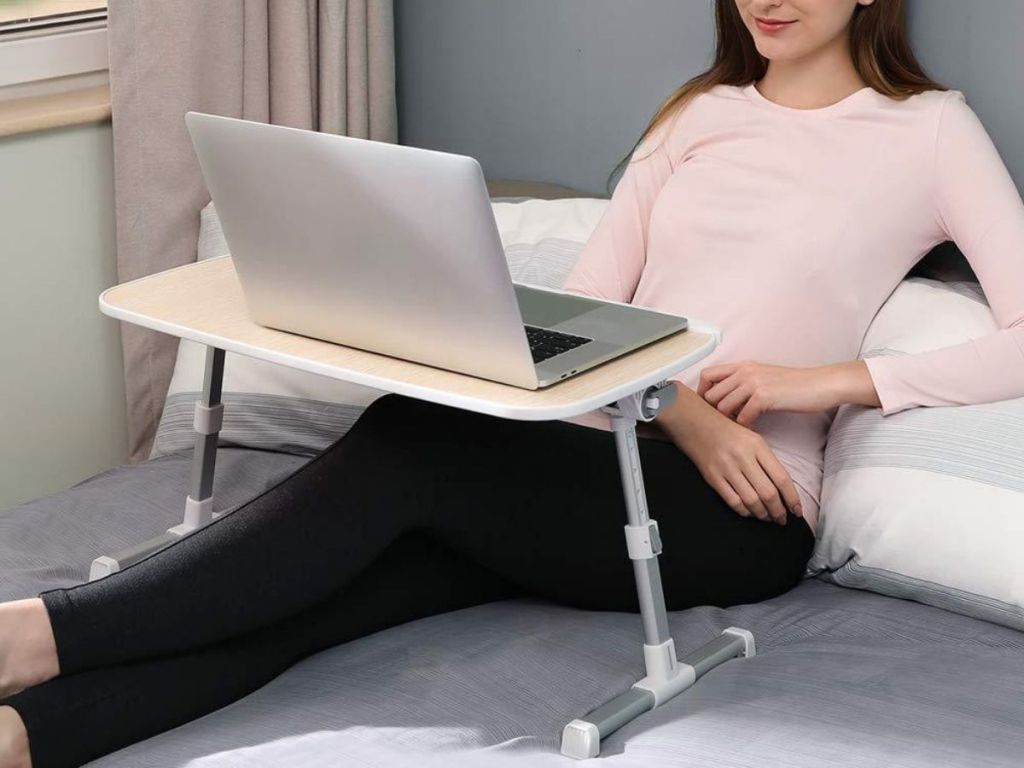 woman using Taotronics Laptop Desk in bed
