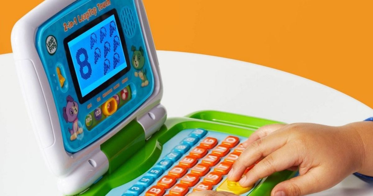 kid playing on a LeapFrog laptop touch toy
