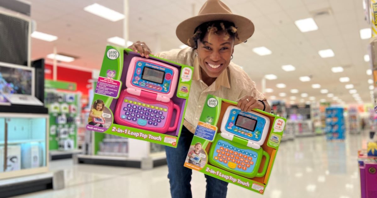 woman holding two LeapFrog leaptop touch toy laptops in a Target store aisle