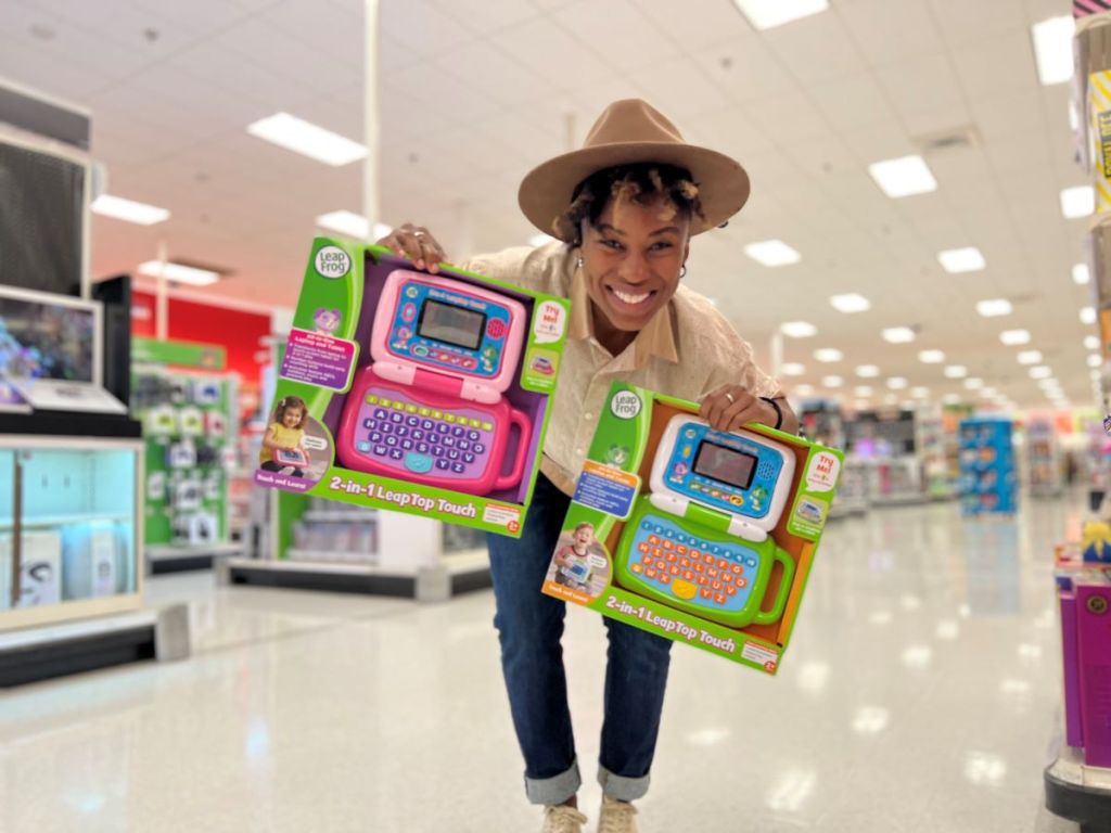 woman holding two toy laptops