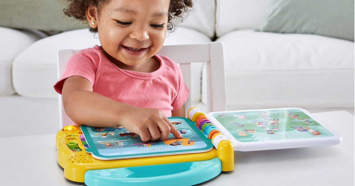 Little girl playing with leapfrog 100 words book