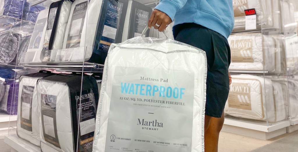 person carrying a Martha Stewart Waterproof Mattress Pad