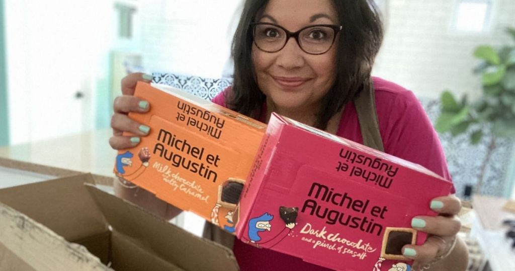 woman holding boxes of Michel et Augustin Gourmet Treats