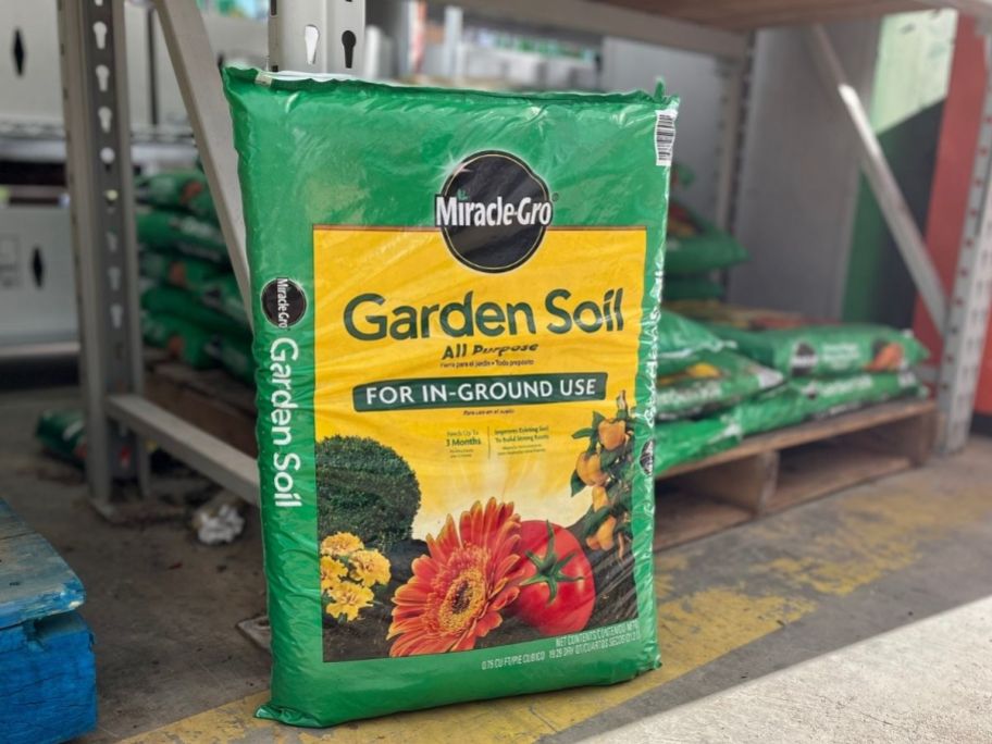 bag of Miracle Gro Garden Soil on floor of store in front of pallet