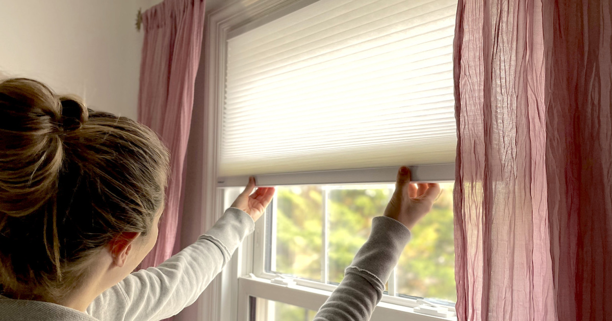 Woman opening blinds