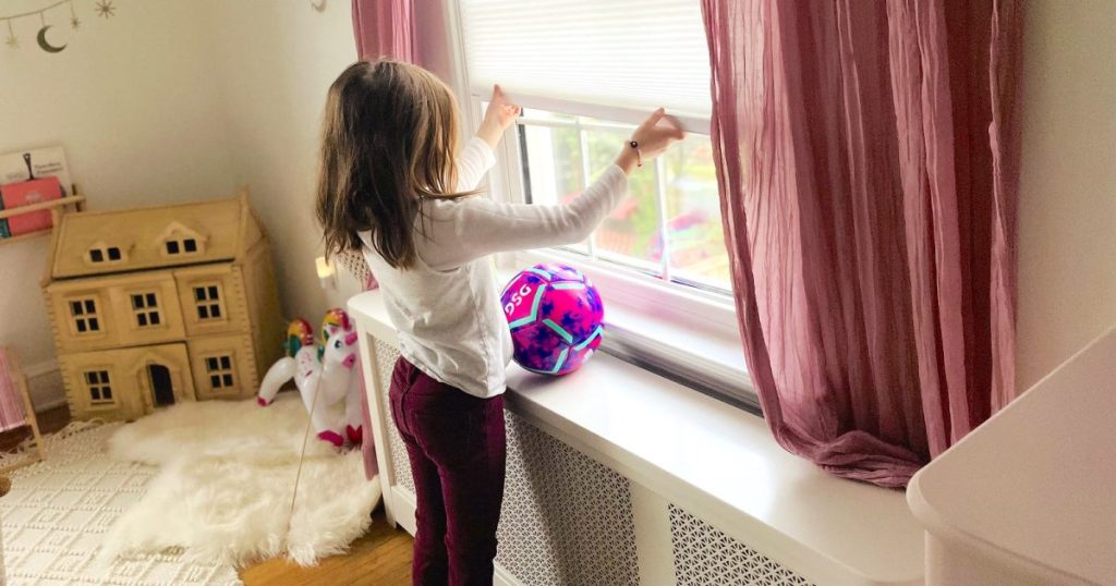 child opening cordless blinds