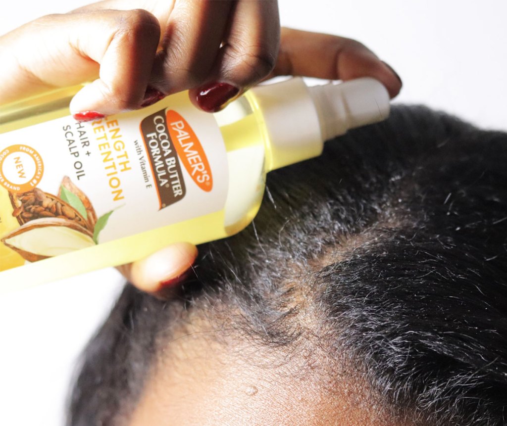 applying Palmer's Cocoa Butter hair oil to scalp