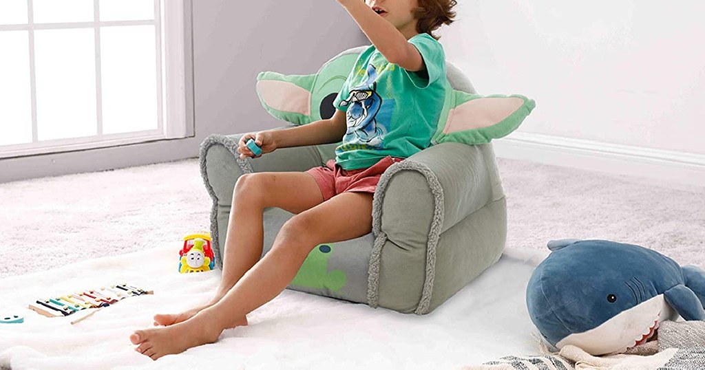 boy sitting in Grogu chair in playroom