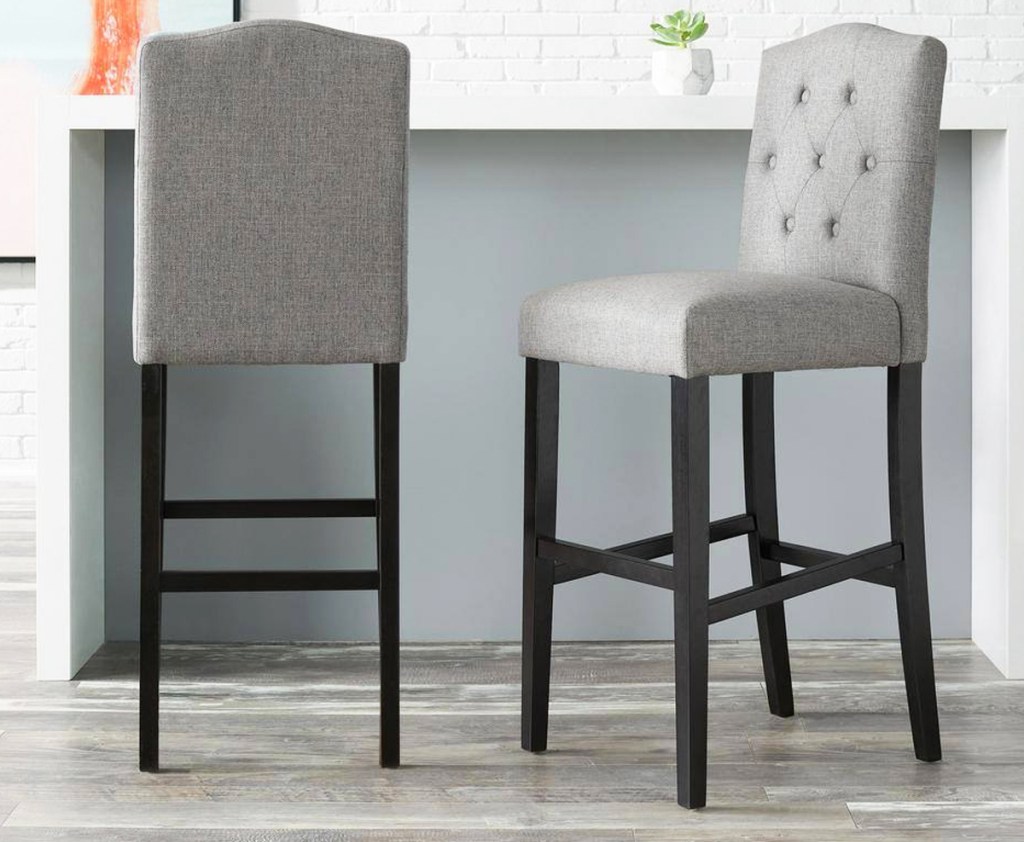 two grey upholstered tufted bar bar stools