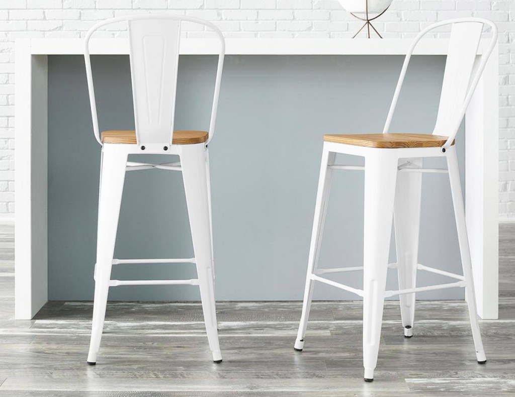two white metal bar stools with wood seats