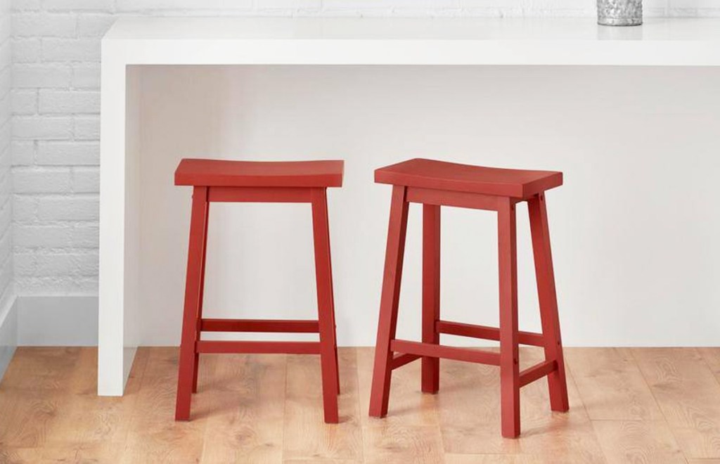 two red backless stools at counter