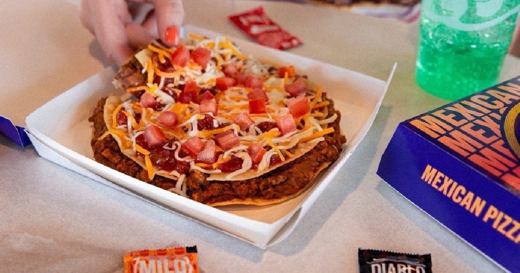 person eating Taco Bell Mexican Pizza