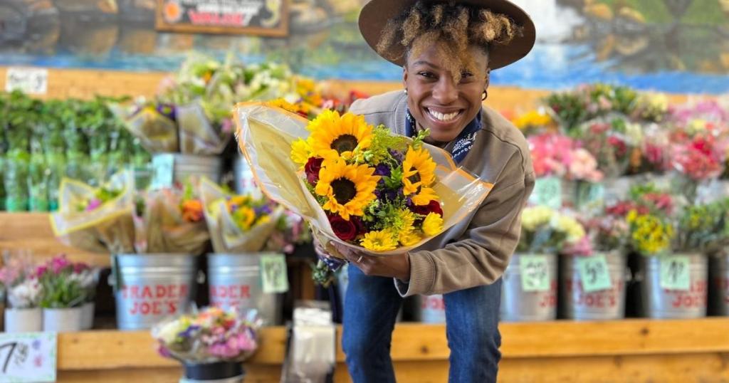 woman holding sunflower bouquet from trader joe's