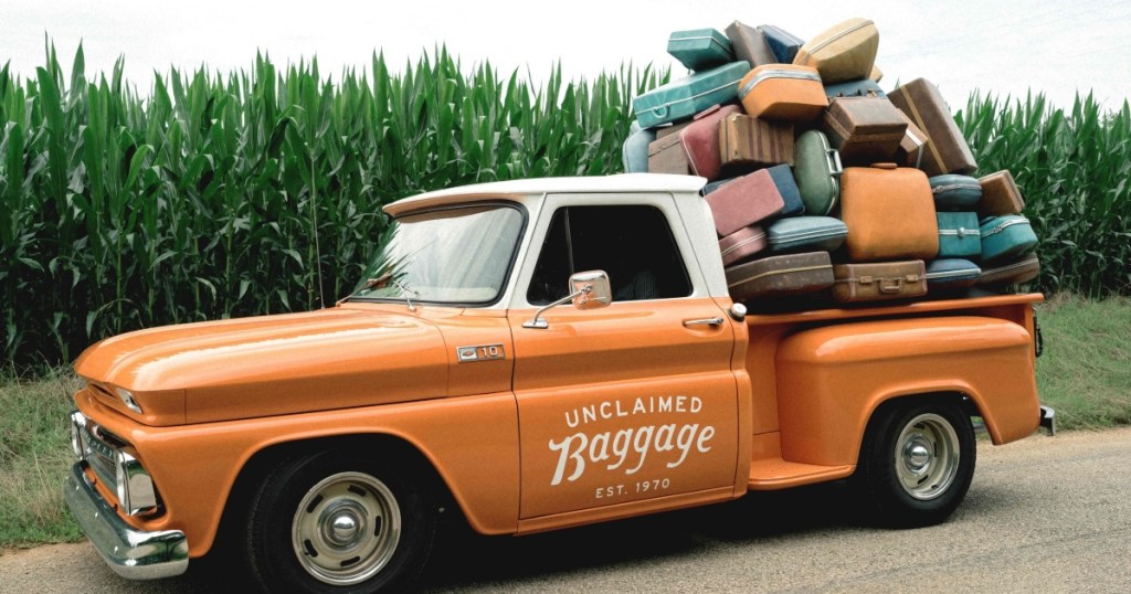 orange pickup truck loaded with luggage