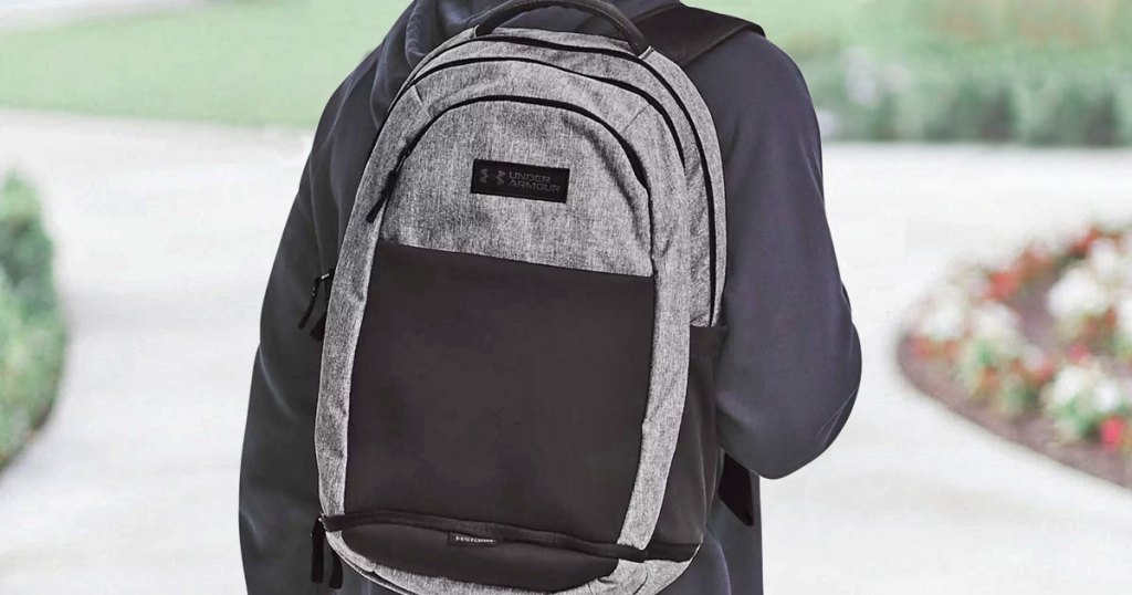man wearing grey under armour backpack