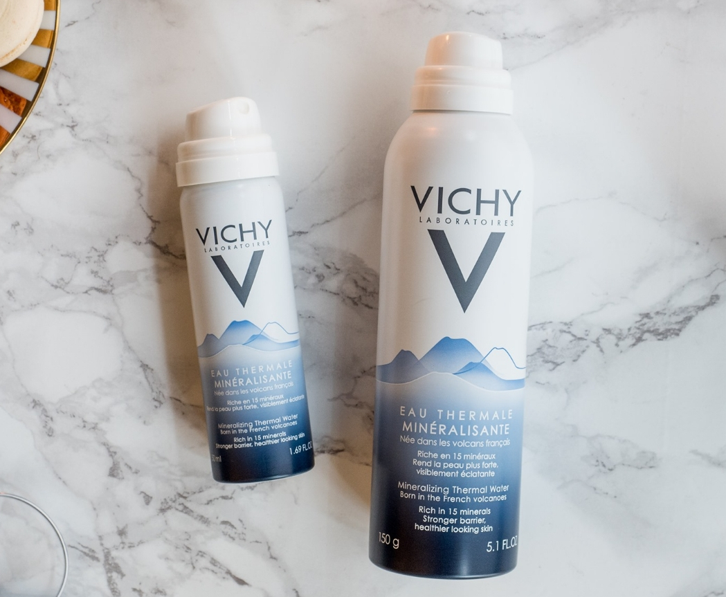 two cans of Vichy water sprays laying on a table
