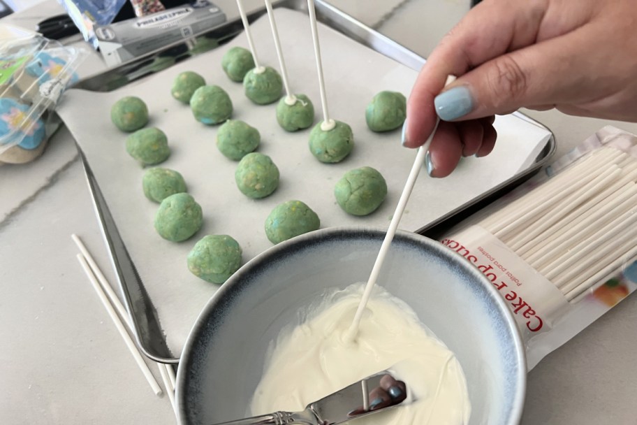 adding cake pop sticks to cake pops