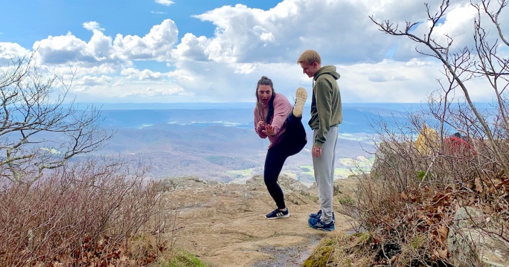 man and woman being funny on top of mountain