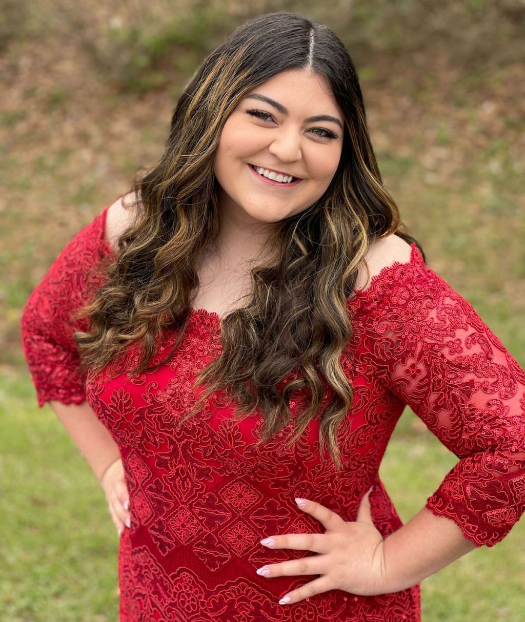 teen girl posing in red lace prom dress