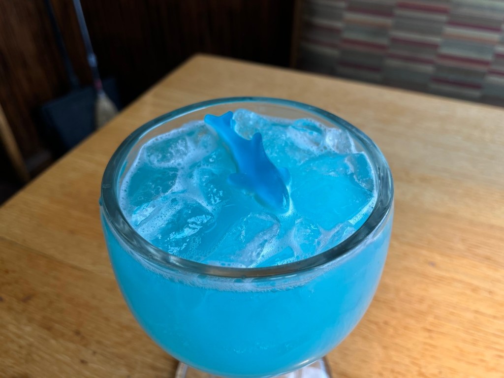 blue cocktail garnished with a gummy shark