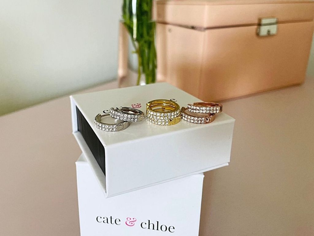 2 Cate & Chloe boxes stacked with 3 pairs of hoop earrings resting on top box