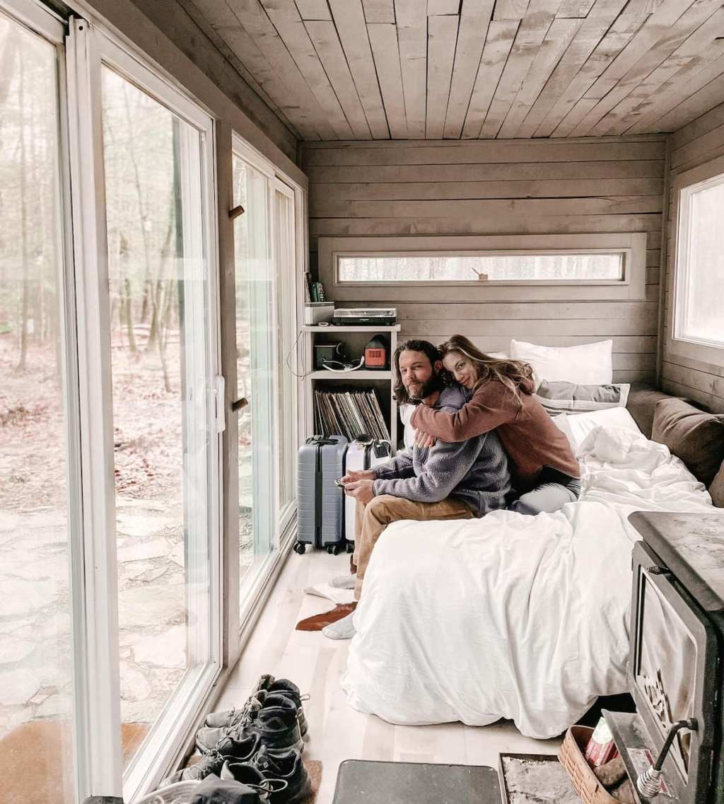 couple sitting on bed in shipping container