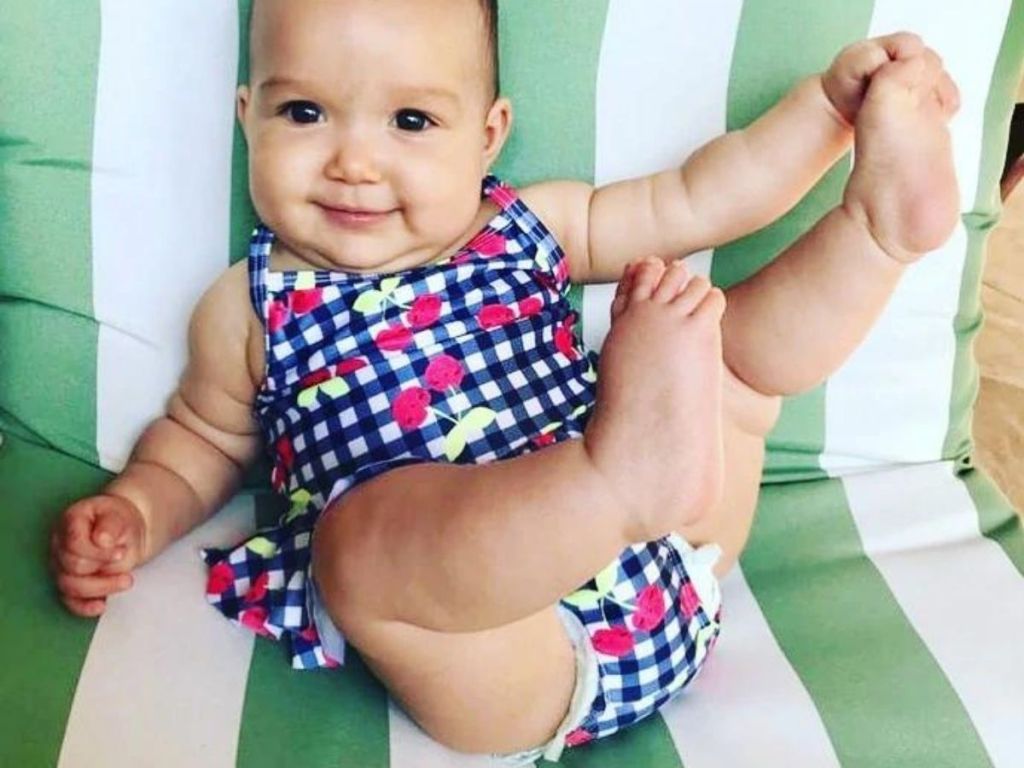 baby girl wearing cherry ruffle swimsuit