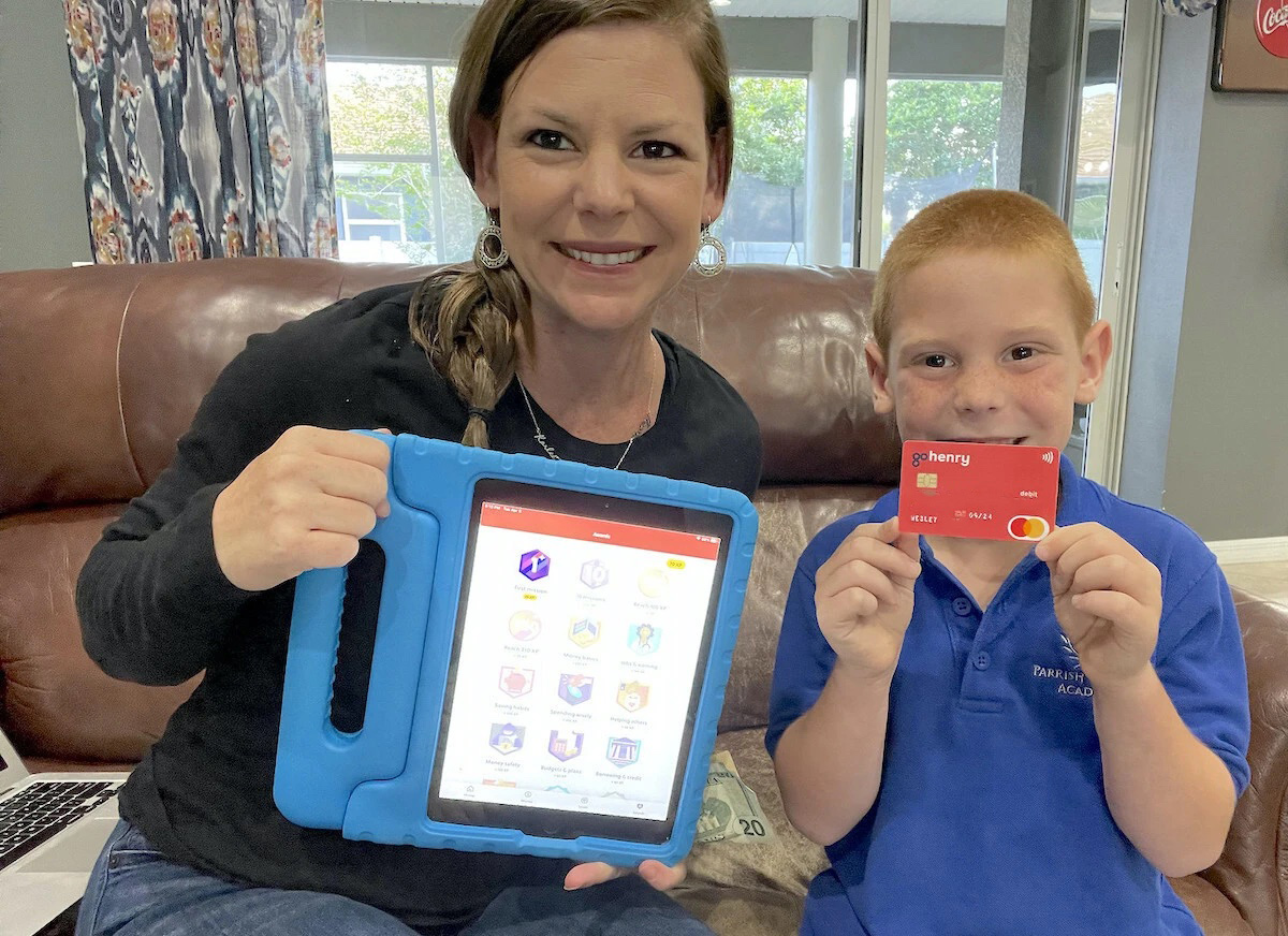 mom and son holding gohenry debit card and ipad
