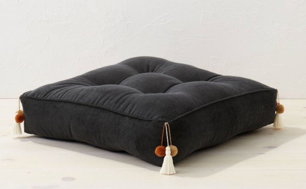 stock photo of black corduroy floor pillow with tassels 