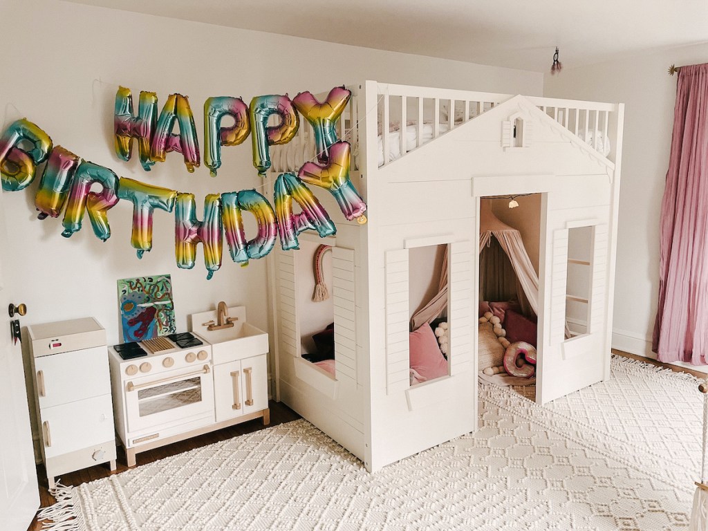 kids room with white bunk loft bed and colorful happy birthday balloons