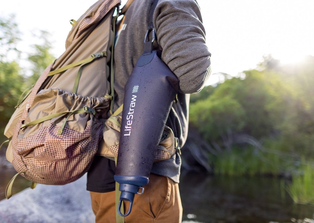 person carrying lifestraw water filter pack and backpack on outdoor hike sustainable products and eco friendly products