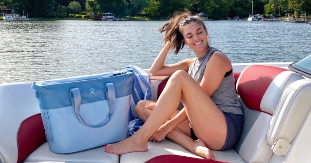 woman and blue hydro flask cooler sitting on boat