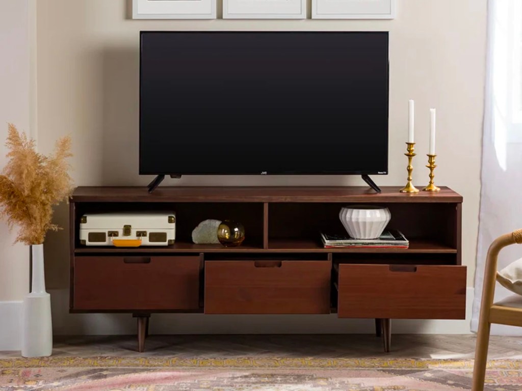 brown media console with tv, and candles on top