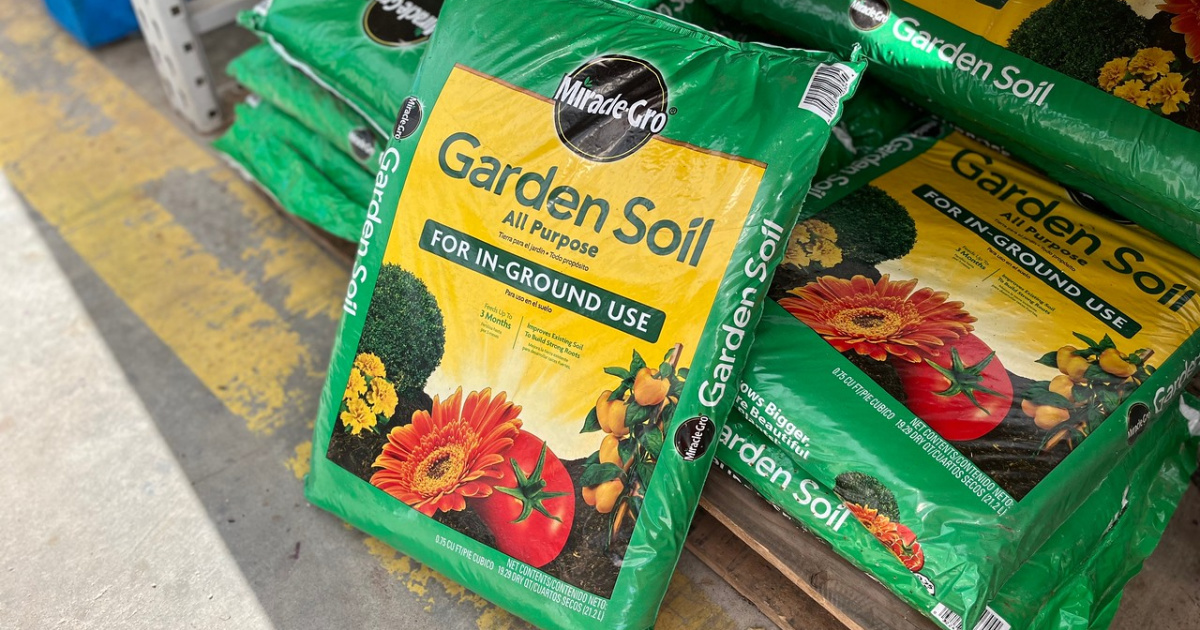 bag of miracle-gro soil leaning up against palette of other bags