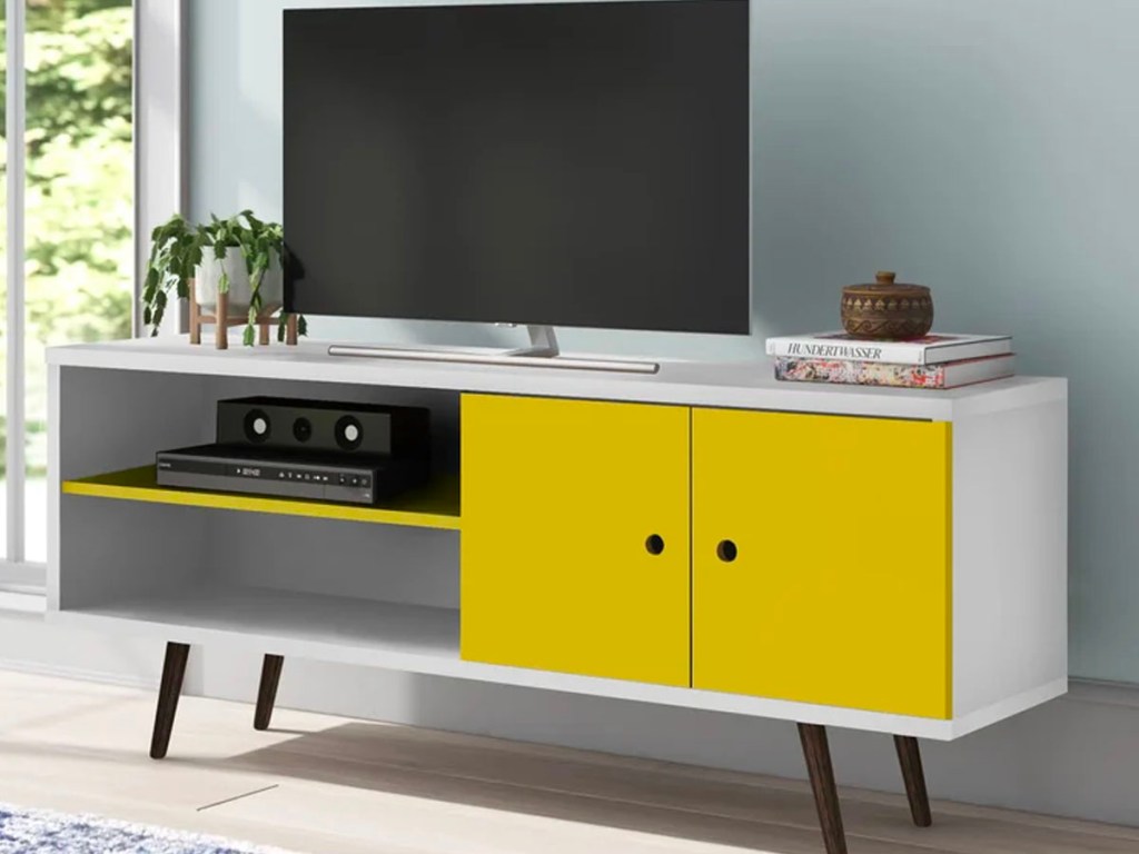 yellow and white tv stand with tv on top in living room