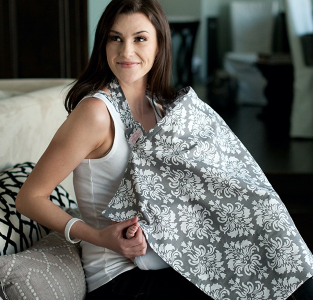 woman sitting on couch with nursing cover