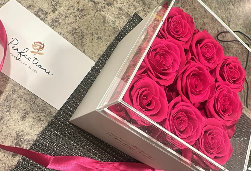 9 pink roses in a box with a clear lid