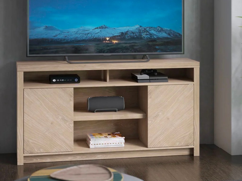 light brown tv stand with tv, dvd player and speaker 